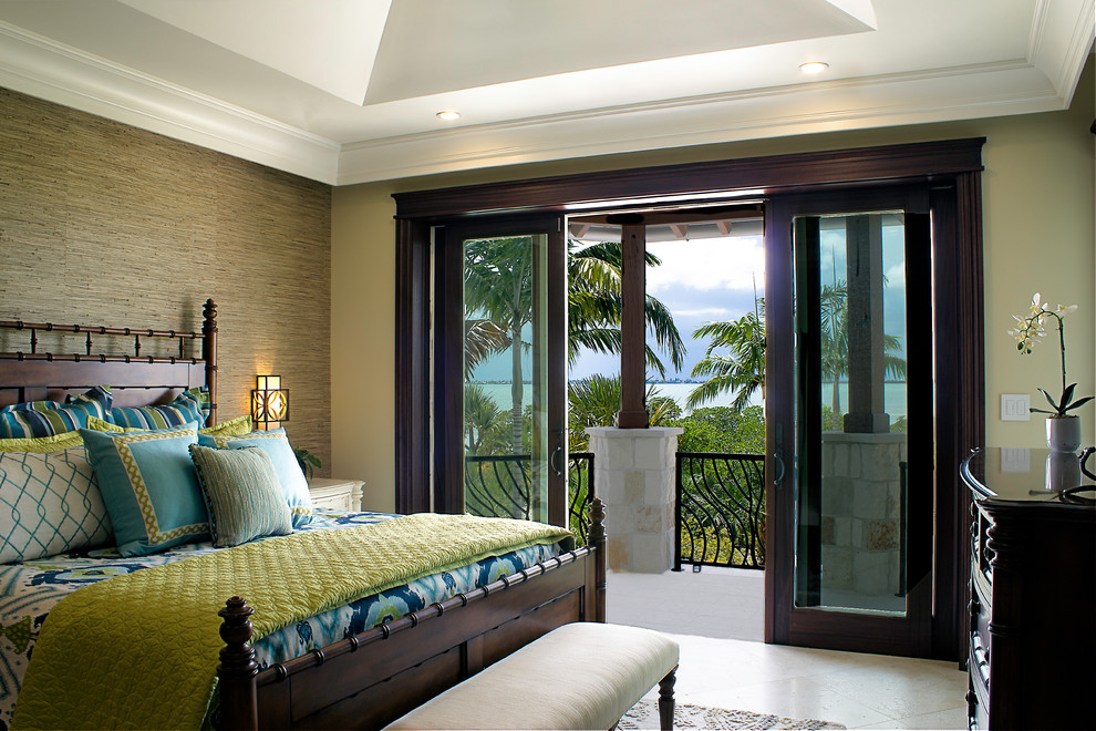 マイアミにある広いトロピカルスタイルのおしゃれな客用寝室 (ベージュの壁、トラバーチンの床、暖炉なし、ベージュの床) のインテリア