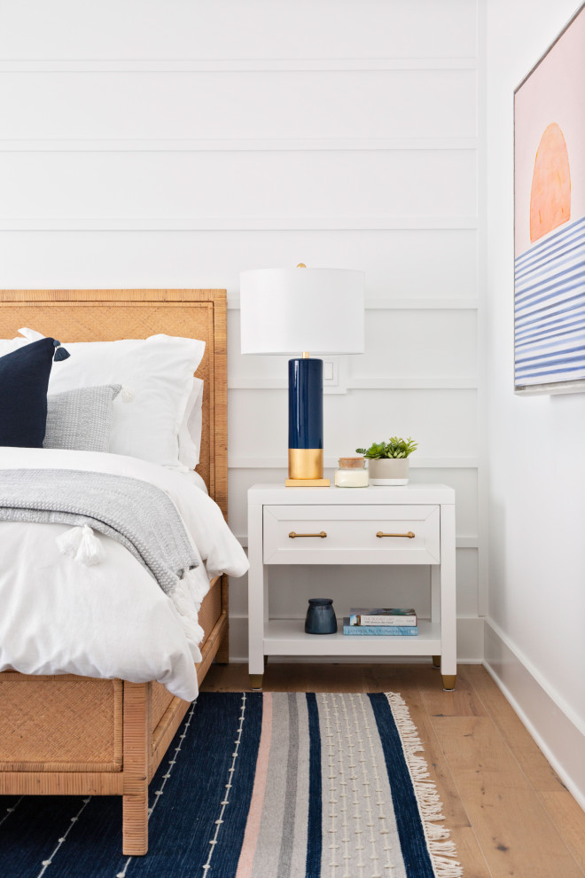 Esempio di una camera da letto stile marinaro di medie dimensioni con pareti bianche, pavimento in legno massello medio, pavimento beige e pareti in perlinato