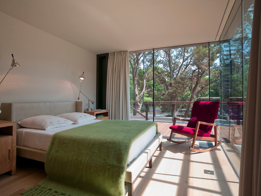 Imagen de habitación de invitados moderna pequeña sin chimenea con paredes beige, suelo de madera en tonos medios y suelo marrón
