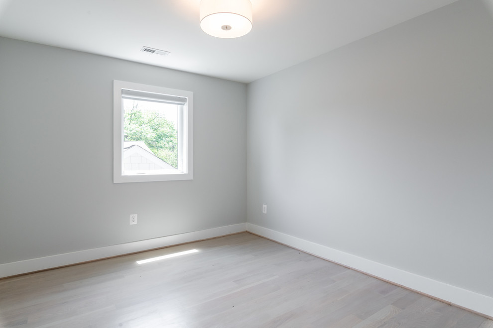 Cette image montre une chambre design de taille moyenne avec un mur gris, parquet clair et un sol gris.