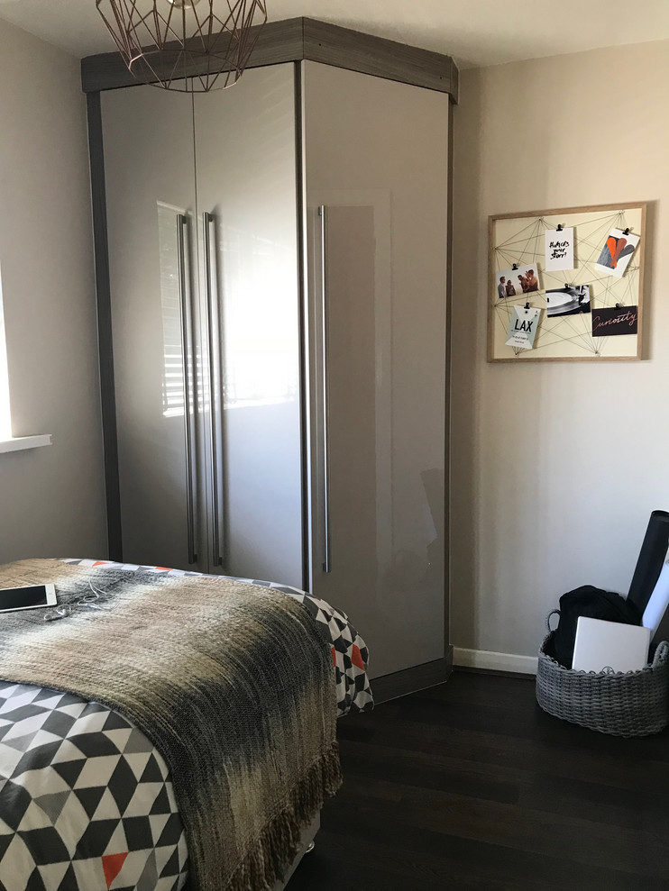 Imagen de habitación de invitados contemporánea pequeña con paredes beige, suelo laminado y suelo marrón