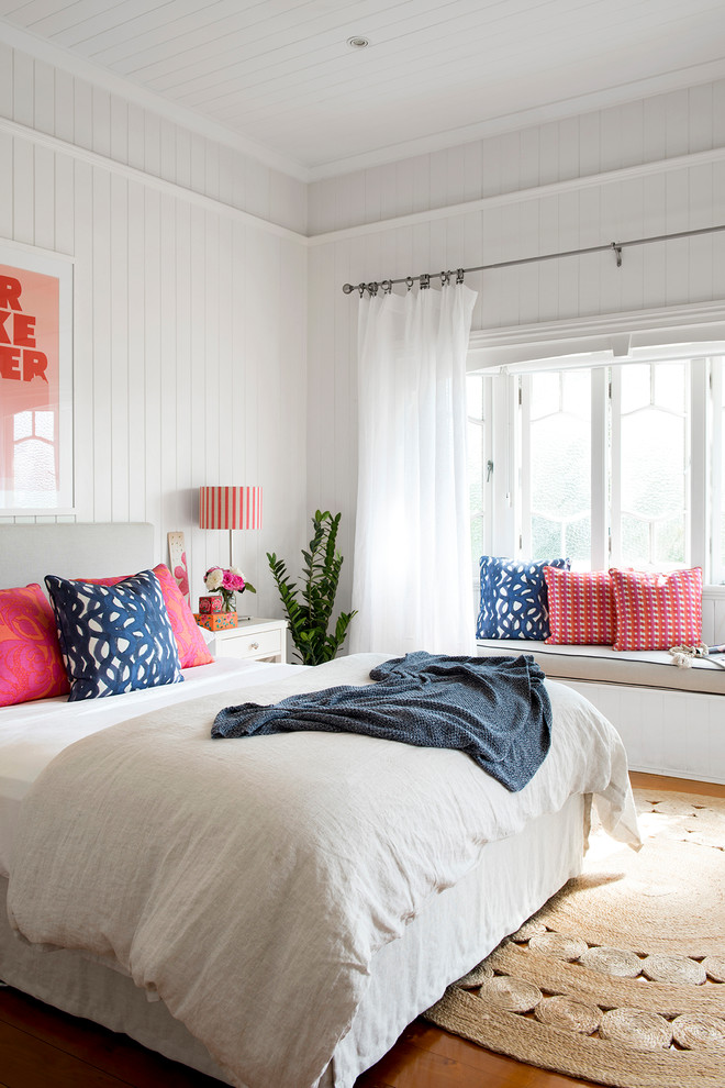Foto di una camera da letto stile marino con pareti bianche, pavimento in legno massello medio e pavimento marrone