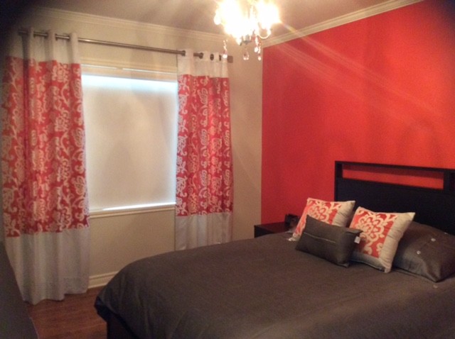 Modelo de habitación de invitados clásica renovada con parades naranjas y suelo de madera en tonos medios
