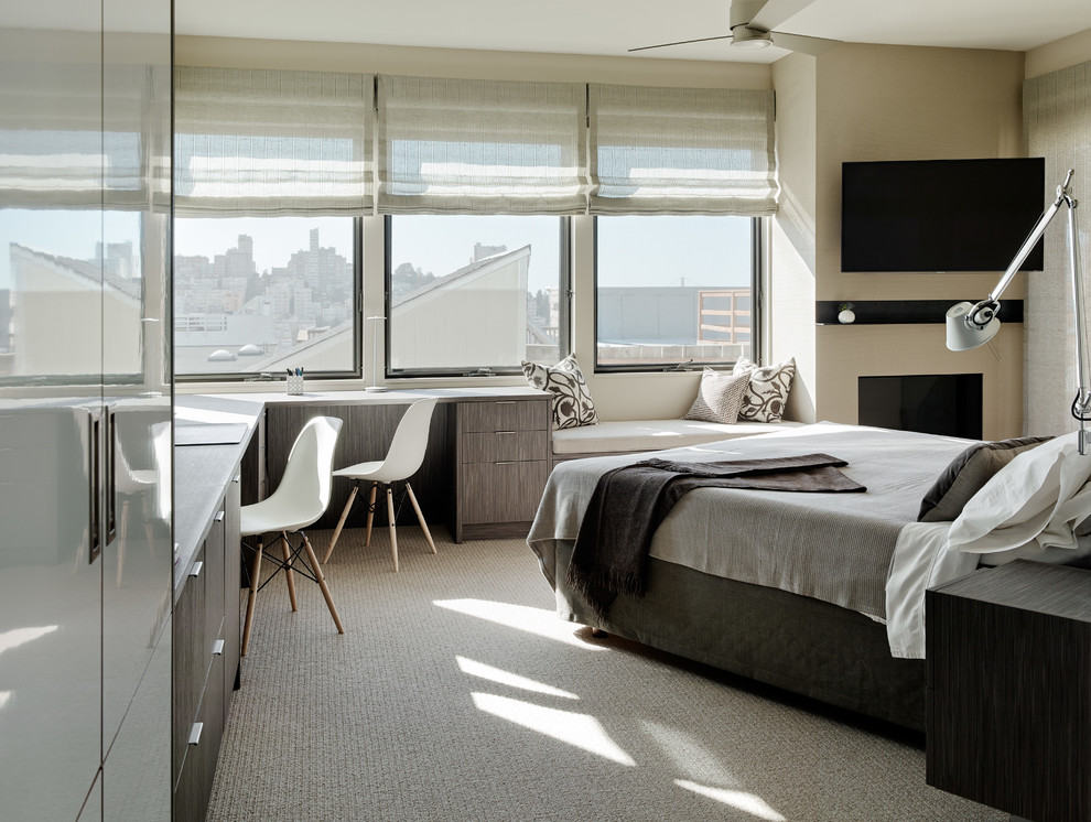 На фото: спальня в современном стиле с бежевыми стенами, ковровым покрытием и стандартным камином