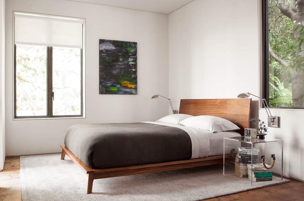 Imagen de habitación de invitados moderna de tamaño medio con paredes blancas y suelo de madera clara