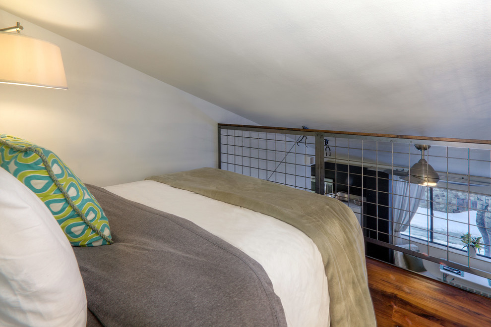 Ejemplo de dormitorio tipo loft contemporáneo pequeño con paredes blancas y suelo de madera en tonos medios
