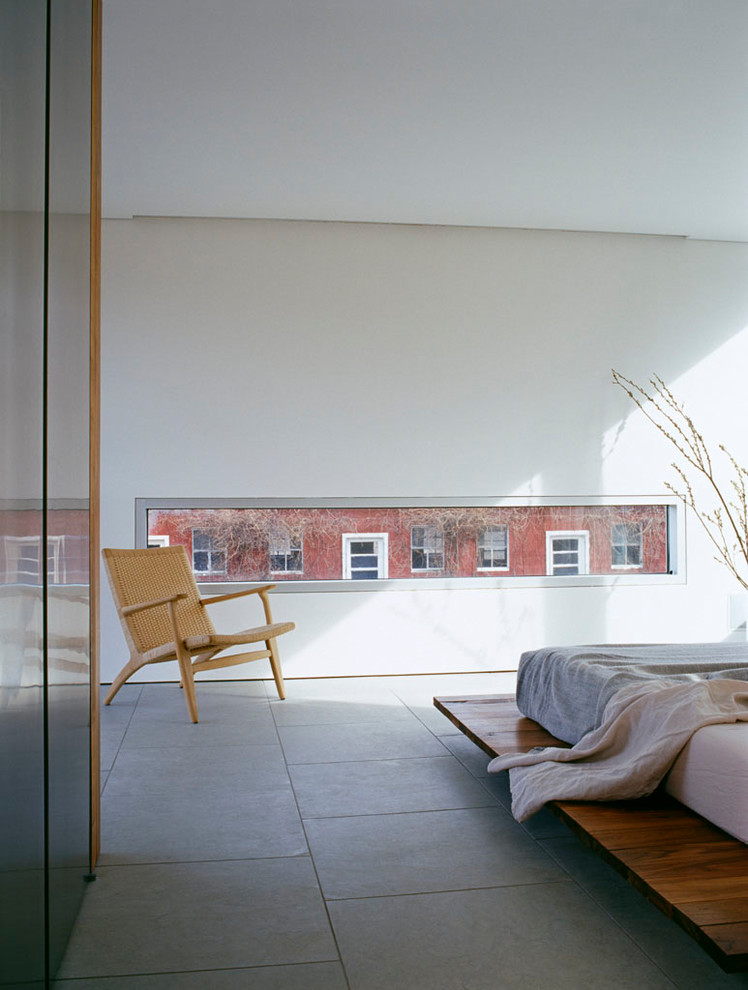 Diseño de dormitorio actual con paredes blancas, suelo de piedra caliza y suelo gris