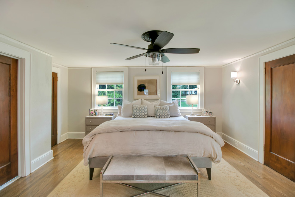 Example of a large transitional master medium tone wood floor and brown floor bedroom design in New York with gray walls