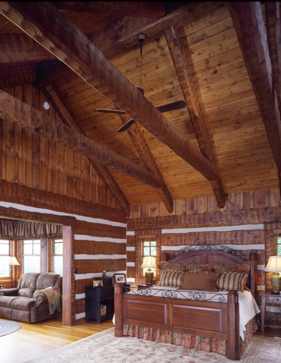 Cette photo montre une très grande chambre parentale montagne avec un sol en bois brun.
