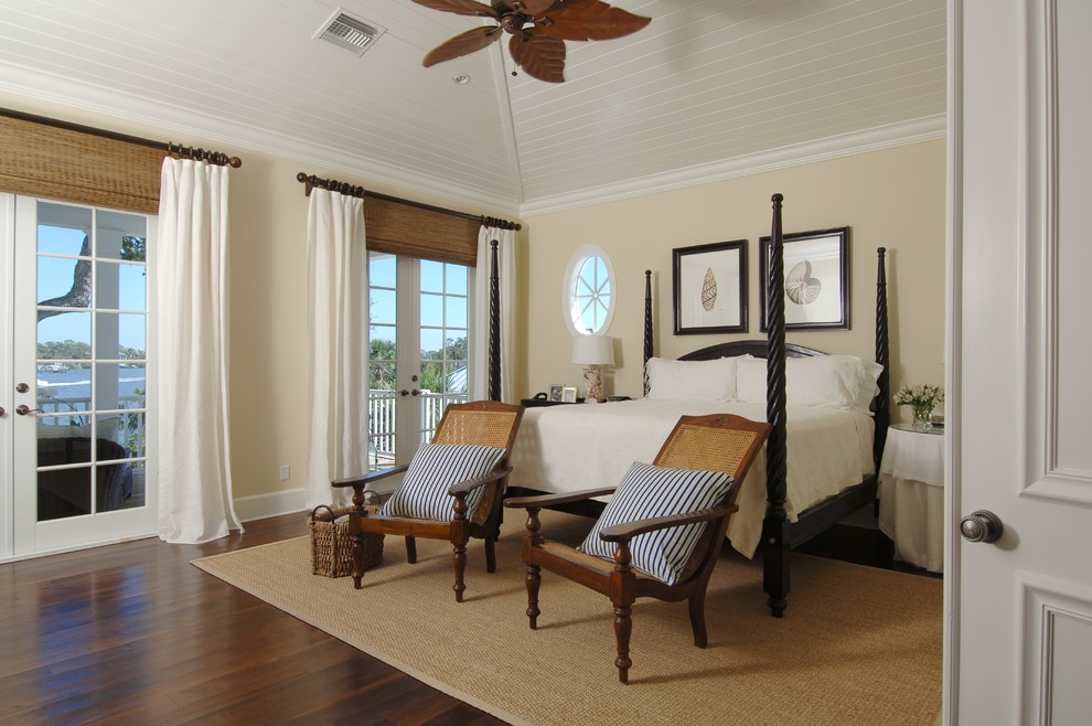 Design ideas for a large coastal master bedroom in Miami with beige walls and dark hardwood flooring.