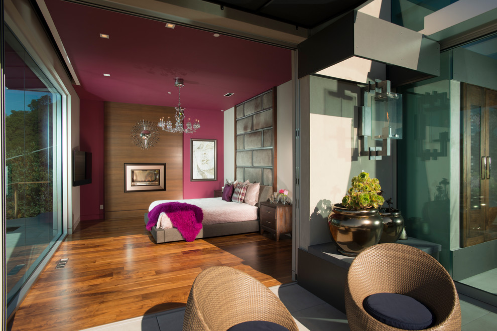 Inspiration pour une grande chambre parentale design avec un mur violet et parquet foncé.