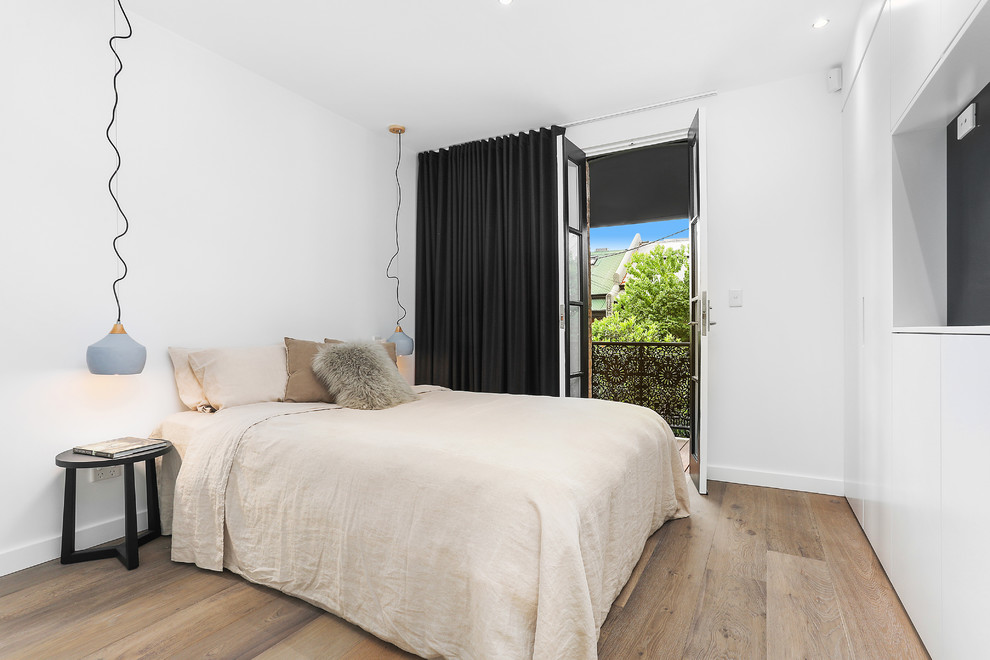 Exemple d'une petite chambre d'amis tendance avec un mur blanc, un sol en bois brun et un sol marron.