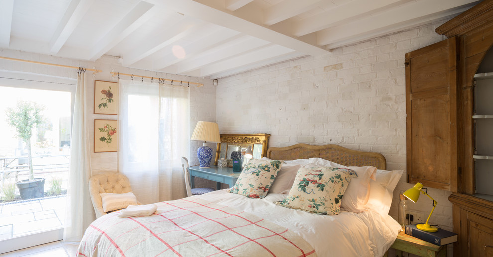 Modelo de habitación de invitados de estilo de casa de campo de tamaño medio sin chimenea con paredes blancas, suelo de baldosas de cerámica y suelo beige
