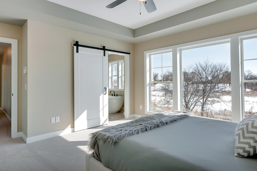 Ejemplo de dormitorio principal de estilo de casa de campo de tamaño medio con paredes beige, moqueta y suelo gris
