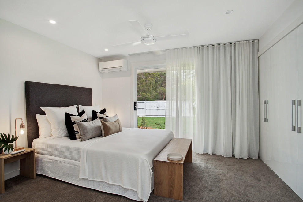 Contemporary master bedroom in Sunshine Coast with white walls and carpet.