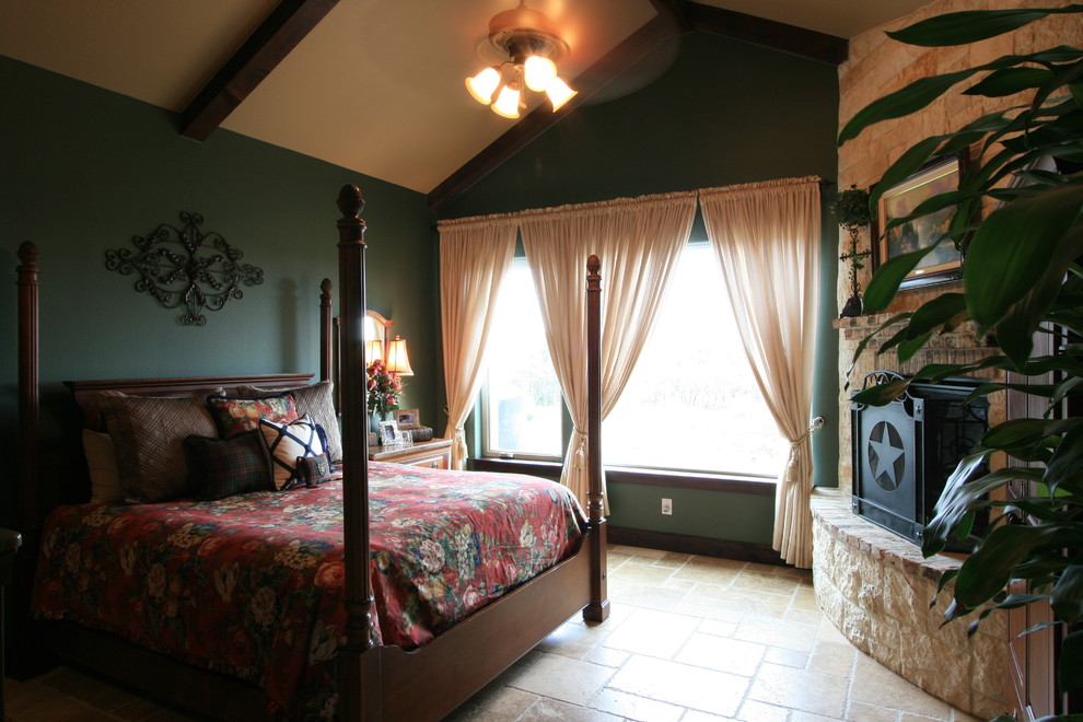 Großes Klassisches Hauptschlafzimmer mit grüner Wandfarbe, Travertin, Eckkamin, Kaminumrandung aus Stein und braunem Boden in Austin