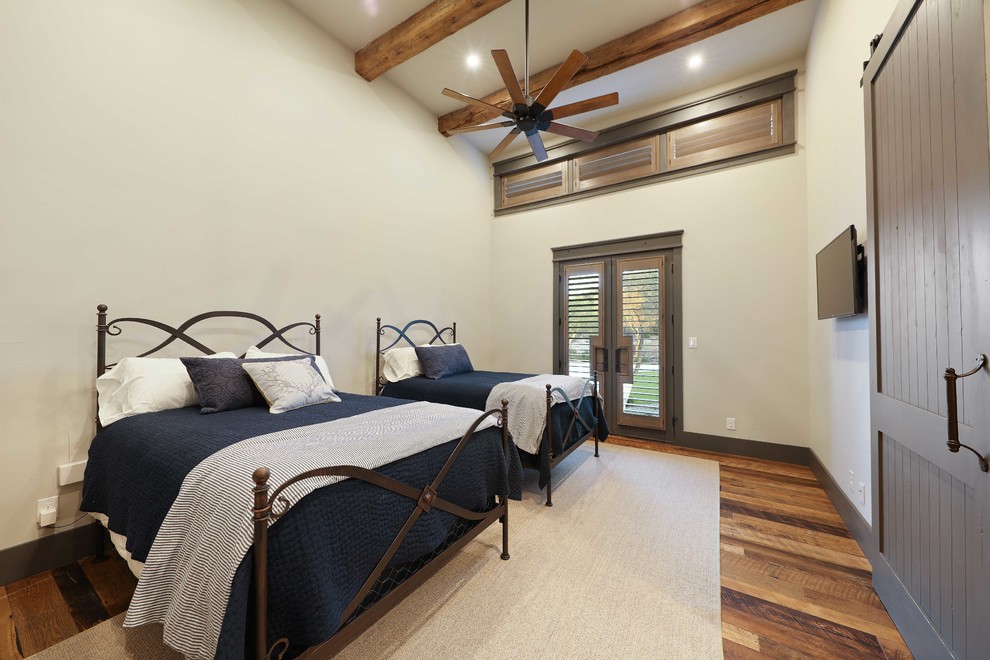 Diseño de habitación de invitados rural extra grande con paredes beige, suelo de madera en tonos medios y suelo marrón