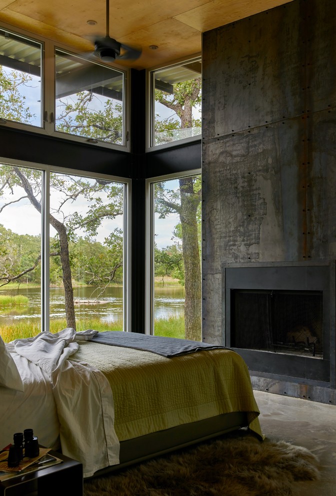 Идея дизайна: спальня среднего размера в стиле неоклассика (современная классика) с бетонным полом, стандартным камином и фасадом камина из металла