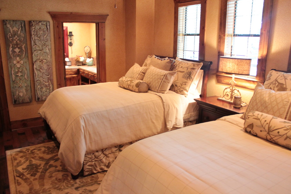 На фото: большая гостевая спальня (комната для гостей) в классическом стиле с бежевыми стенами, темным паркетным полом, стандартным камином и фасадом камина из камня с