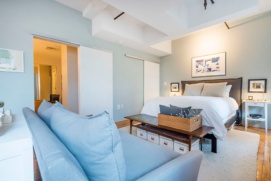 Kleines Modernes Schlafzimmer im Loft-Style mit braunem Holzboden in Houston