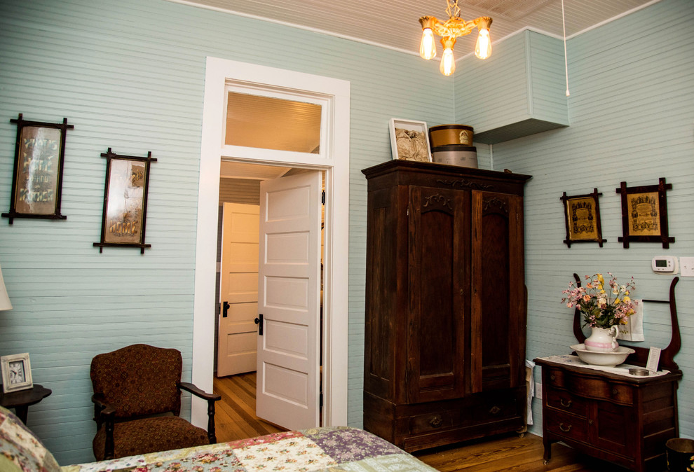 Ejemplo de dormitorio principal campestre de tamaño medio con suelo de madera oscura, suelo marrón y paredes verdes