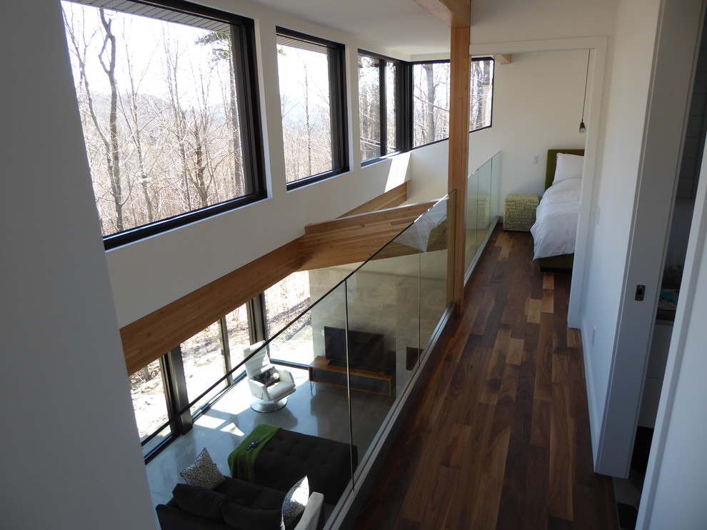 Foto di una piccola camera da letto stile loft moderna con pareti bianche e parquet chiaro