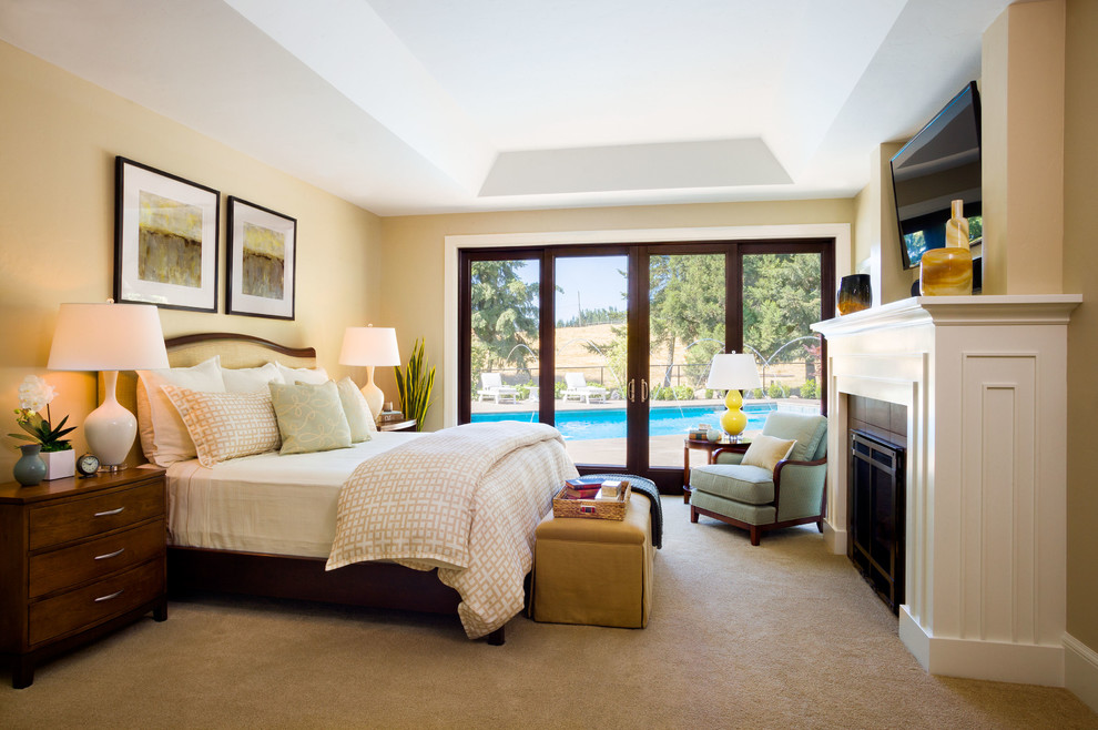 Imagen de dormitorio principal clásico renovado extra grande con paredes beige, moqueta, todas las chimeneas y marco de chimenea de madera