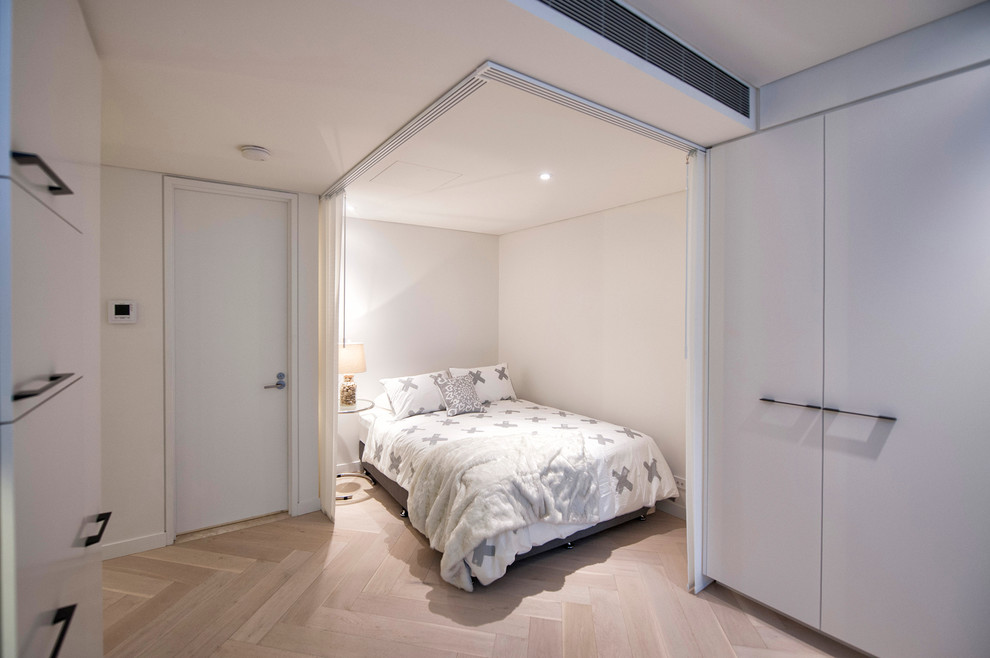 Design ideas for a small contemporary mezzanine bedroom in Sydney with light hardwood flooring and no fireplace.