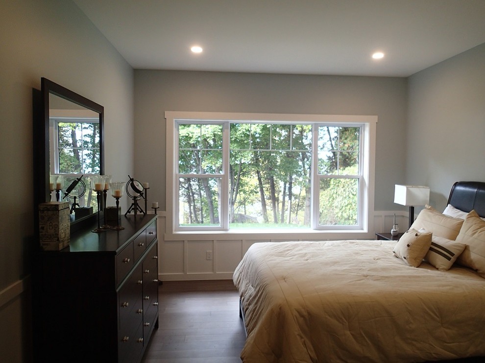 Idée de décoration pour une chambre parentale champêtre de taille moyenne avec un mur bleu et un sol en bois brun.