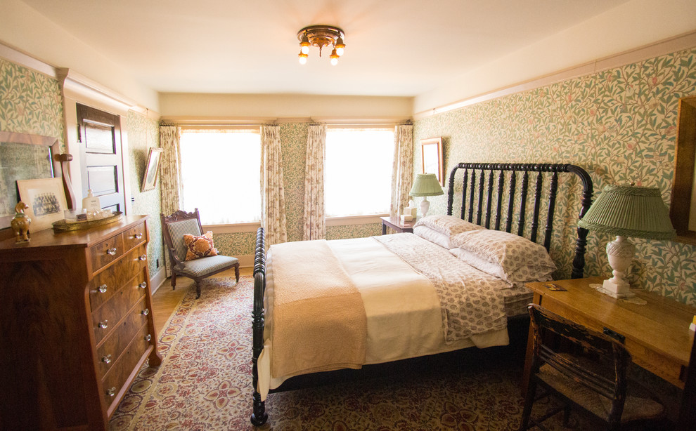 Modelo de habitación de invitados de estilo americano con paredes verdes y suelo de madera en tonos medios