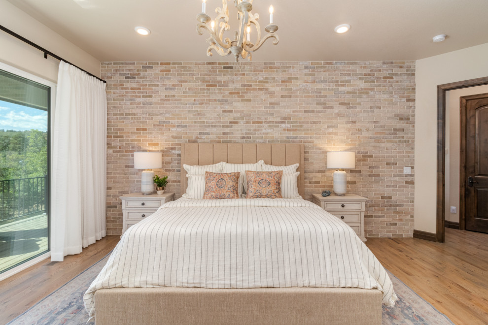 Design ideas for a master bedroom in Denver with light hardwood flooring and brick walls.
