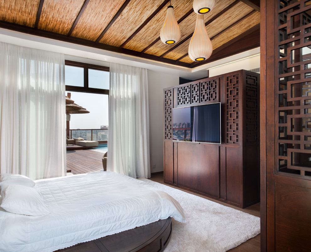 Modelo de dormitorio principal asiático con paredes blancas y suelo de madera en tonos medios