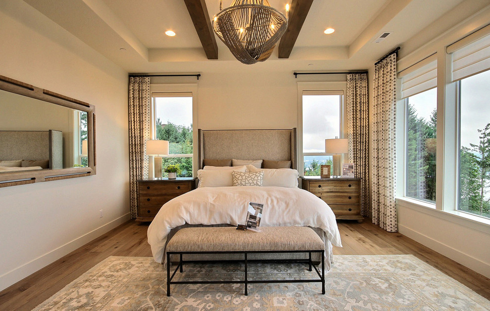 Geräumiges Landhausstil Hauptschlafzimmer mit beiger Wandfarbe, hellem Holzboden, Kamin, Kaminumrandung aus Stein und braunem Boden in Portland