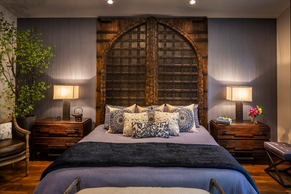 Modelo de dormitorio principal rústico grande sin chimenea con paredes azules, suelo de madera en tonos medios y suelo marrón