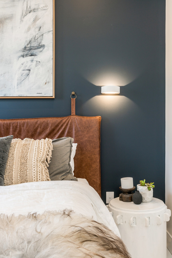 Cette image montre une chambre d'amis design de taille moyenne avec un mur bleu, parquet peint et un sol blanc.