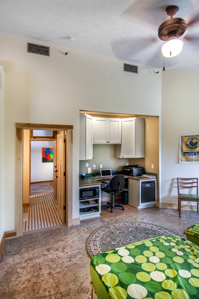 Ejemplo de habitación de invitados de estilo de casa de campo de tamaño medio con paredes amarillas y suelo de cemento