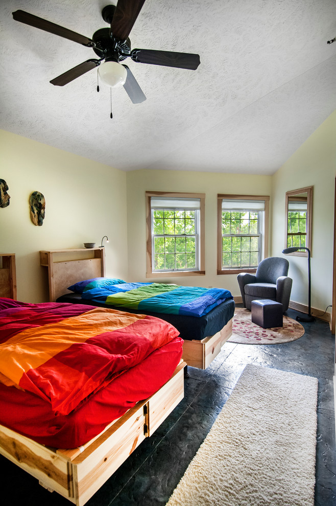 Mittelgroßes Landhausstil Gästezimmer mit gelber Wandfarbe und Betonboden in Omaha