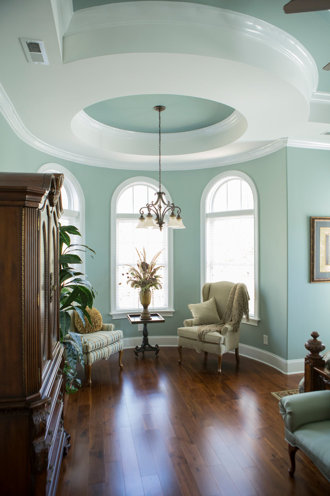 Idée de décoration pour une grande chambre parentale tradition avec un mur bleu et parquet foncé.