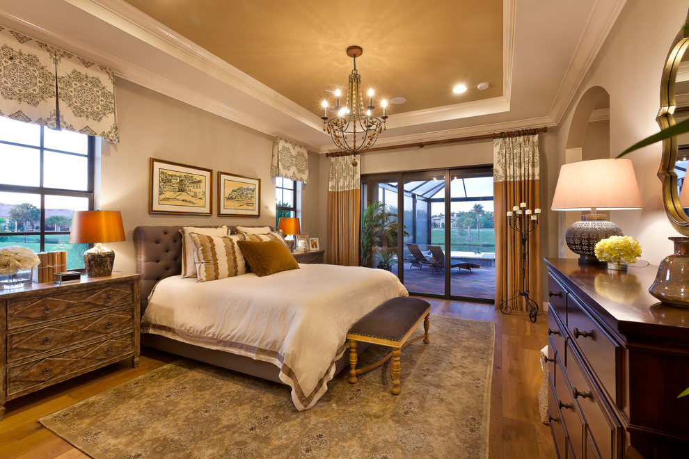 Diseño de dormitorio principal clásico grande con paredes grises y suelo de madera en tonos medios