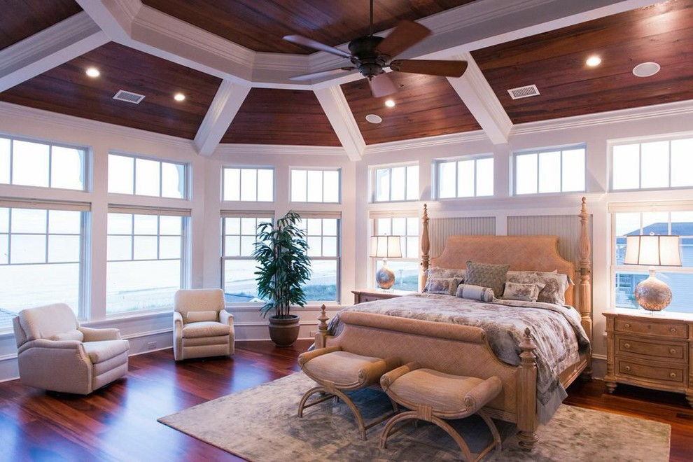 Idée de décoration pour une grande chambre parentale marine avec un mur beige, un sol en bois brun et aucune cheminée.