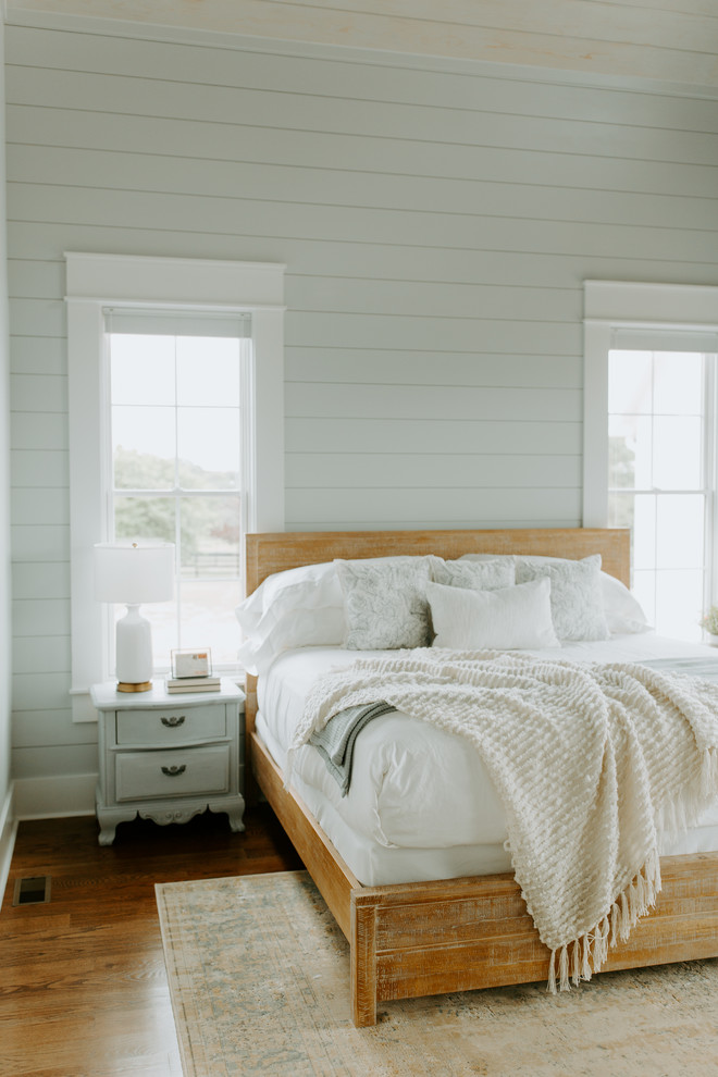 Immagine di una camera degli ospiti country con pareti grigie e pavimento in legno massello medio