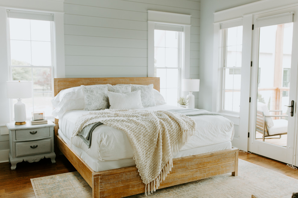 This is an example of a rural guest bedroom in Atlanta with grey walls and medium hardwood flooring.