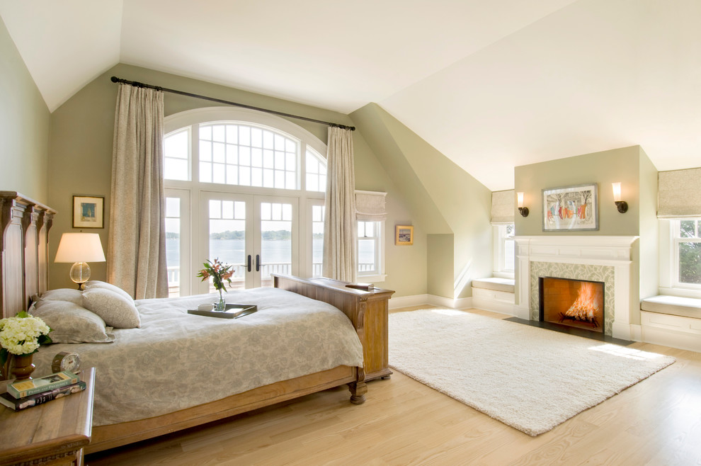 Immagine di una camera da letto chic con pareti beige, parquet chiaro e camino classico