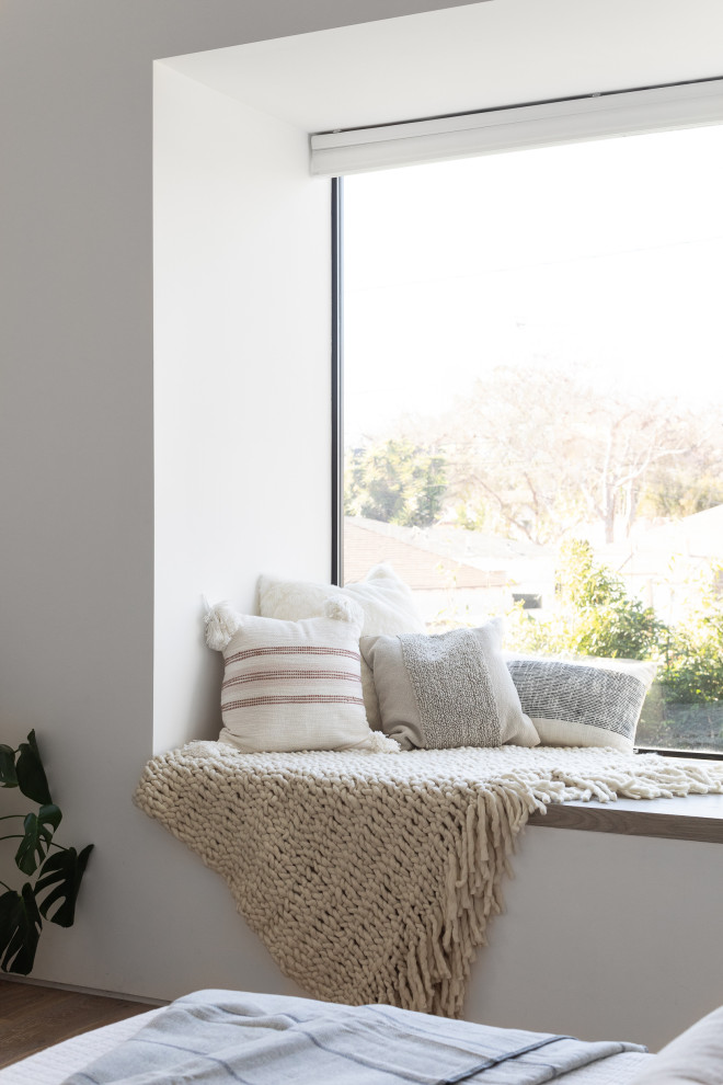 Idée de décoration pour une petite chambre parentale minimaliste avec un mur blanc, parquet clair, aucune cheminée, un sol marron et un plafond voûté.