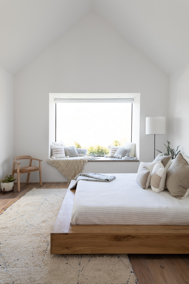 Réalisation d'une petite chambre parentale design avec un mur blanc, un sol en bois brun, un sol marron, un plafond voûté et aucune cheminée.