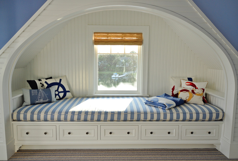 ボストンにある中くらいなビーチスタイルのおしゃれなロフト寝室 (青い壁、カーペット敷き、コーナー設置型暖炉、石材の暖炉まわり、マルチカラーの床) のインテリア