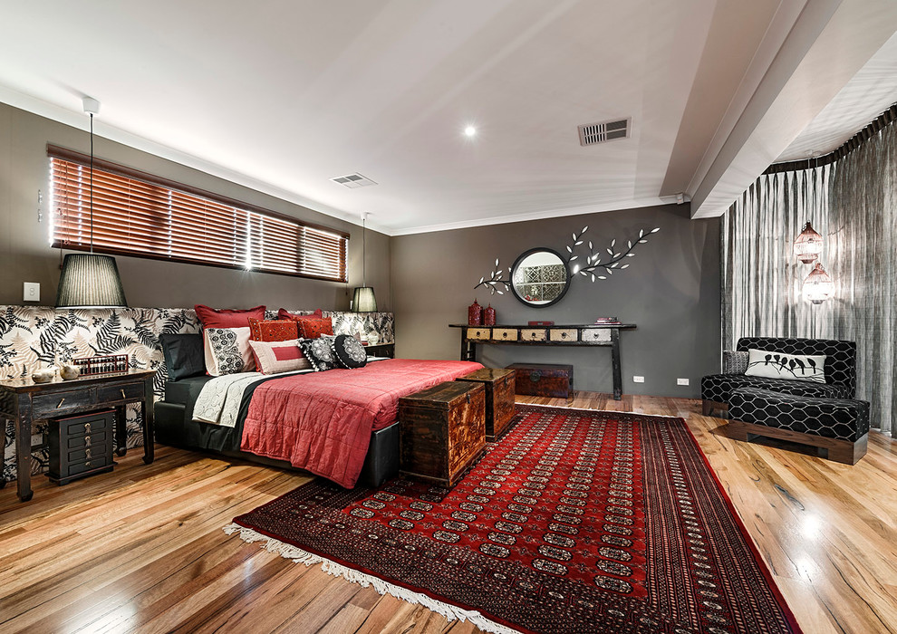 Ejemplo de dormitorio principal bohemio grande con paredes marrones y suelo de madera en tonos medios