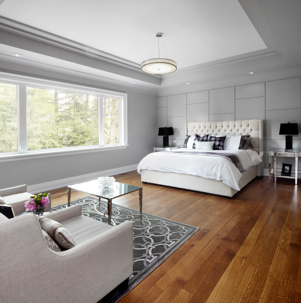 Ejemplo de dormitorio actual con paredes grises y suelo de madera en tonos medios