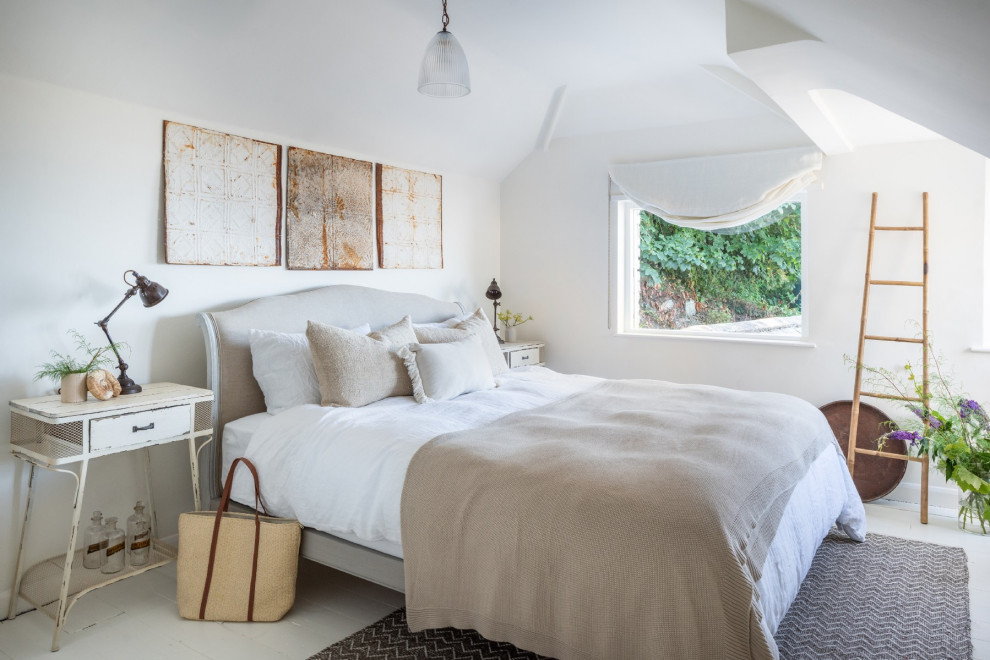 Design ideas for a large beach style master bedroom in Devon with white walls, painted wood flooring and white floors.