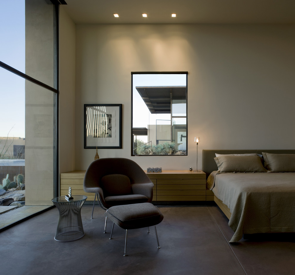 This is an example of a bedroom in Phoenix with beige walls and brown floors.